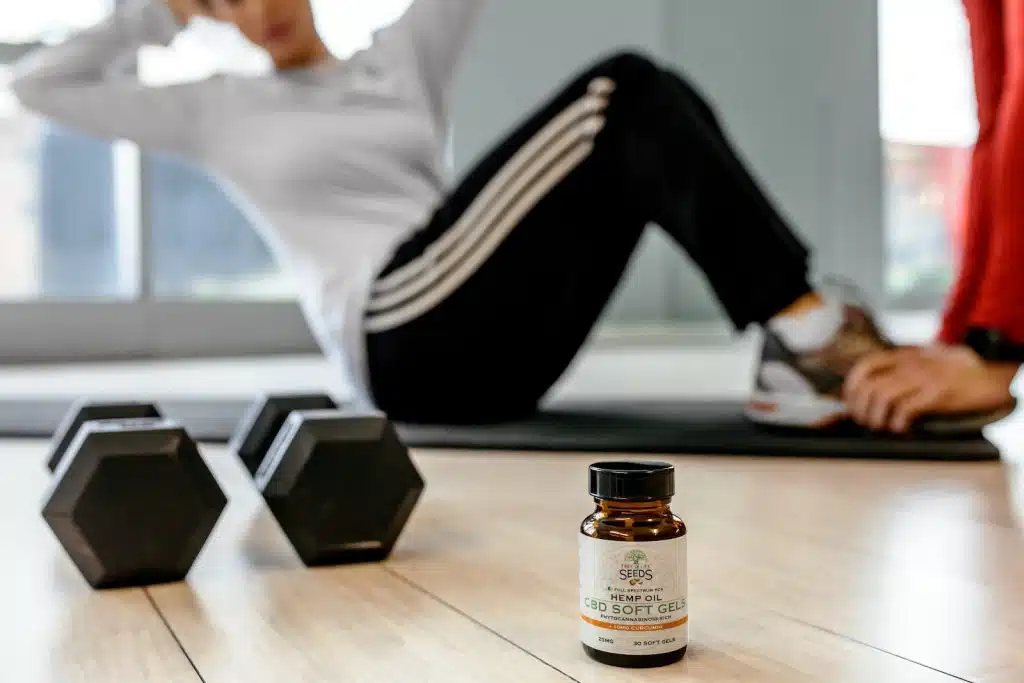 Two Black Dumbbells and Brown Glass Bottle