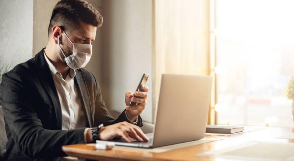 Homme sur pc et smartphone